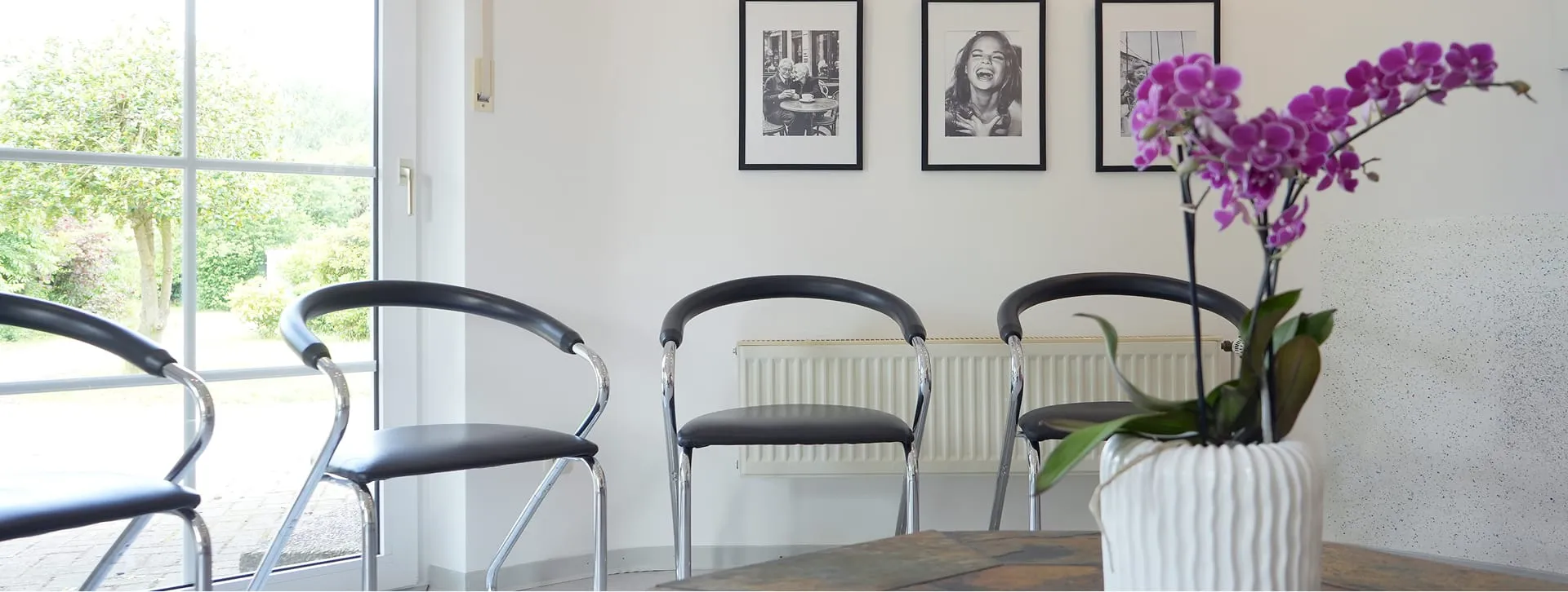 Wartebereich der Praxis mit Sitzplätzen und Orchidee